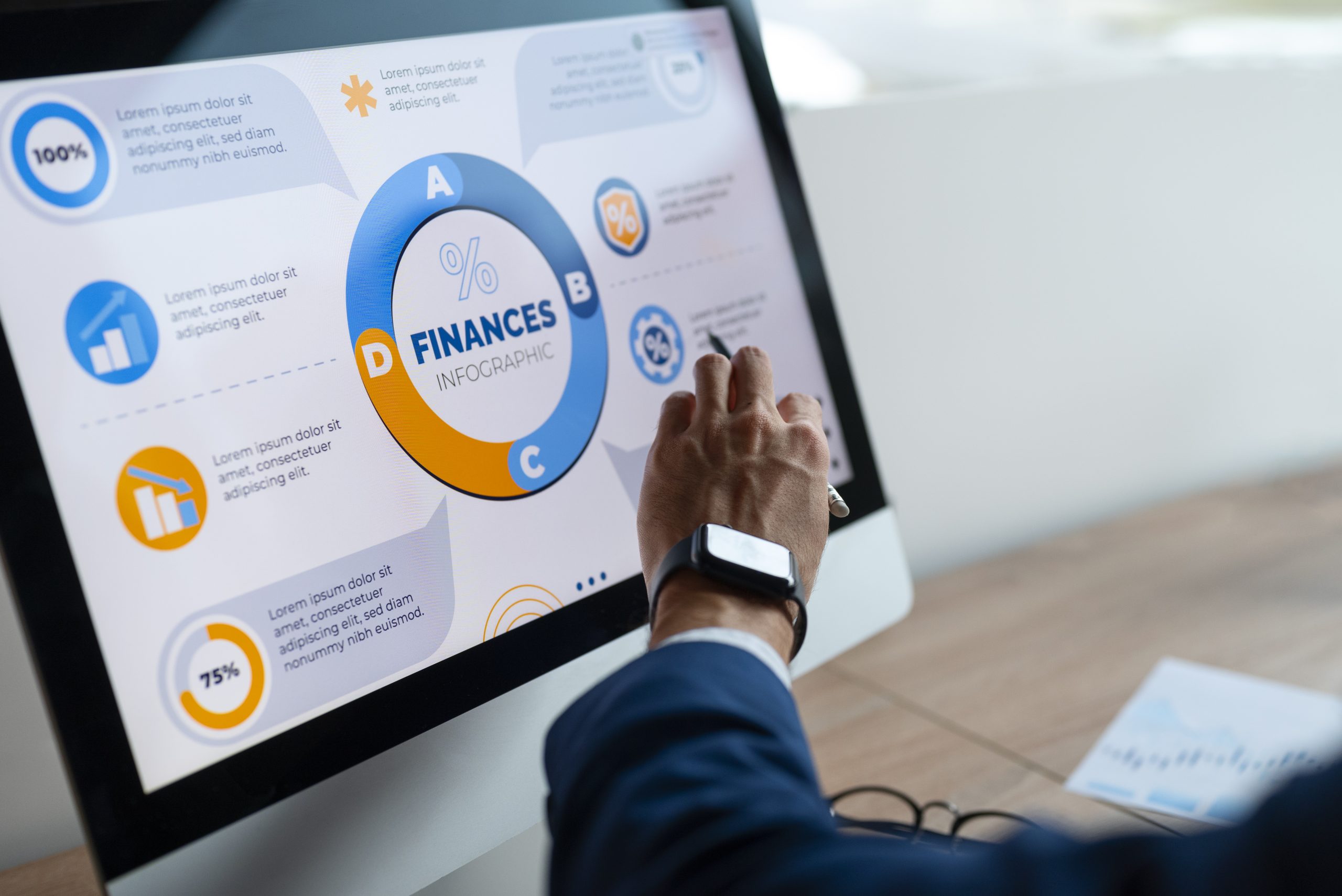 A person interacts with a touchscreen monitor displaying a colorful infographic labeled “Finances,” surrounded by charts and icons, illustrating the process of developing a structured financial plan for better money management and informed decision-making.